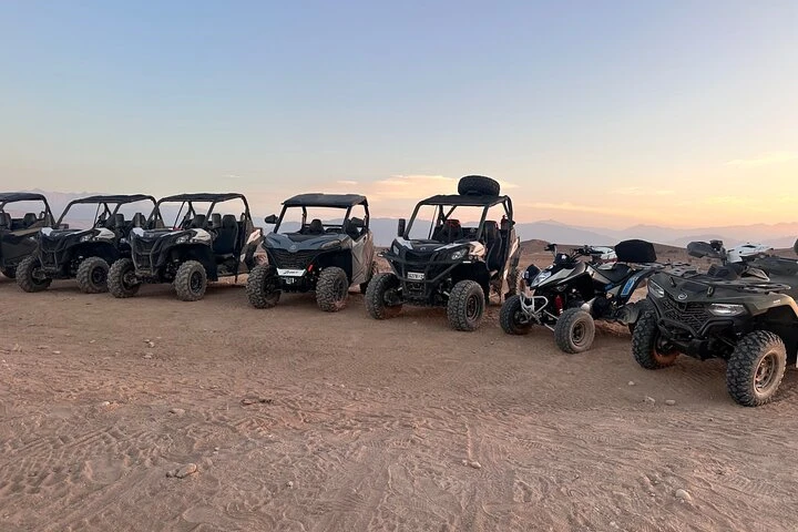 Flotte de buggies alignés au coucher du soleil dans le désert d'Agafay