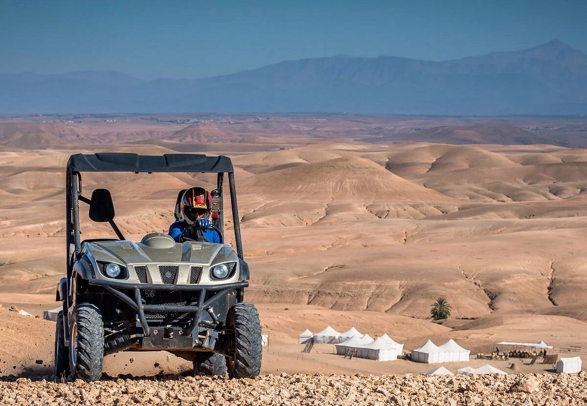 Buggy en action sur les crêtes du désert d'Agafay avec bivouac en fond