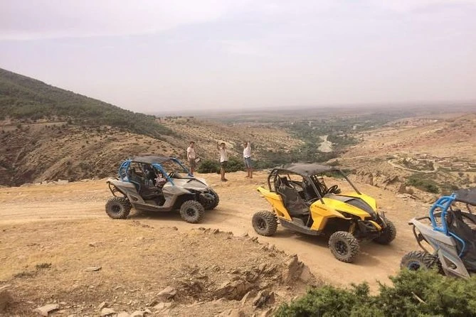 Trio de buggies colorés sur un promontoire avec vue sur la vallée
