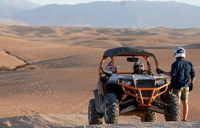 Buggy dans les dunes de sable du désert au coucher du soleil