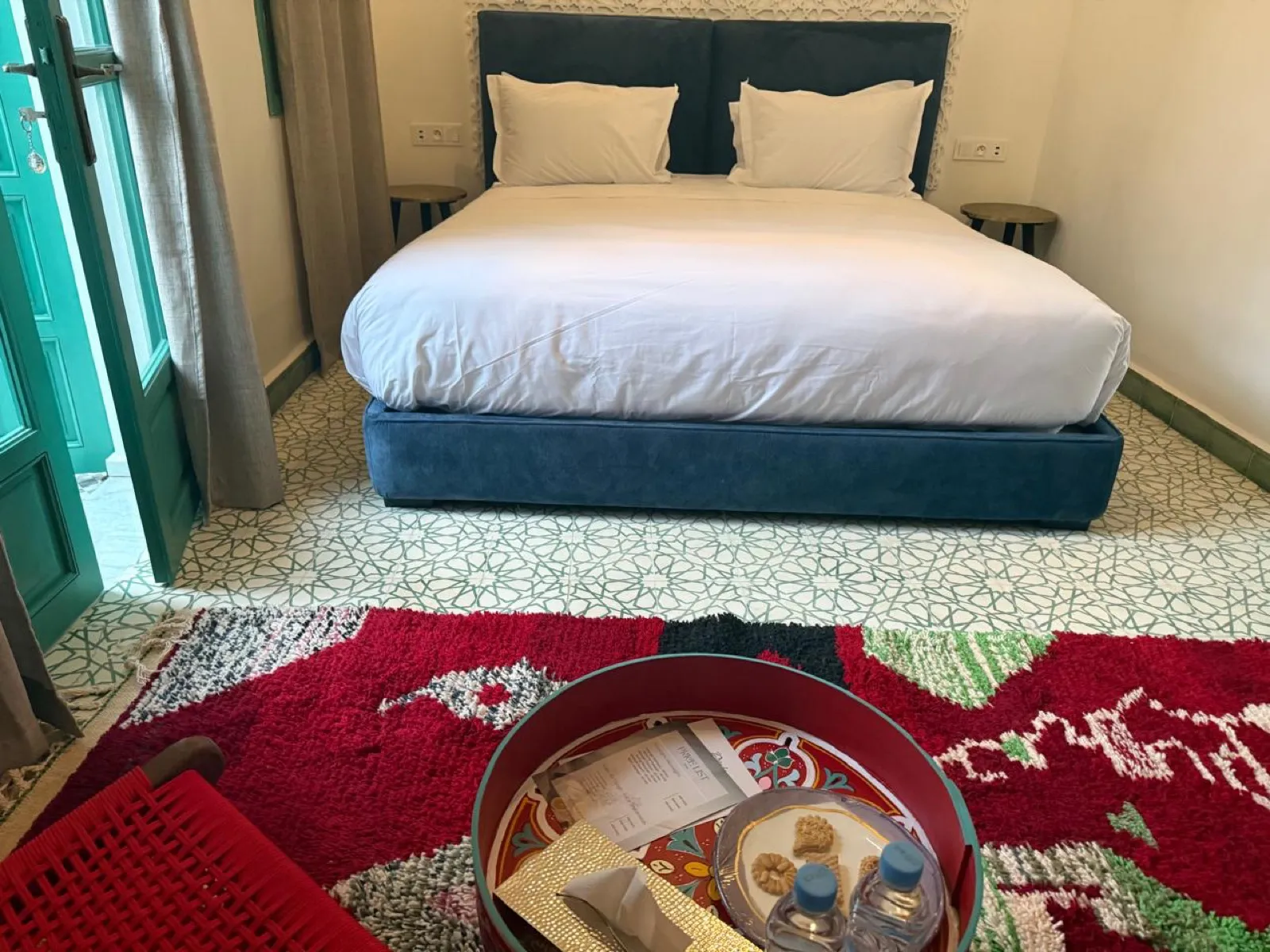 Chambre rouge avec plateau d'accueil et tapis coloré
