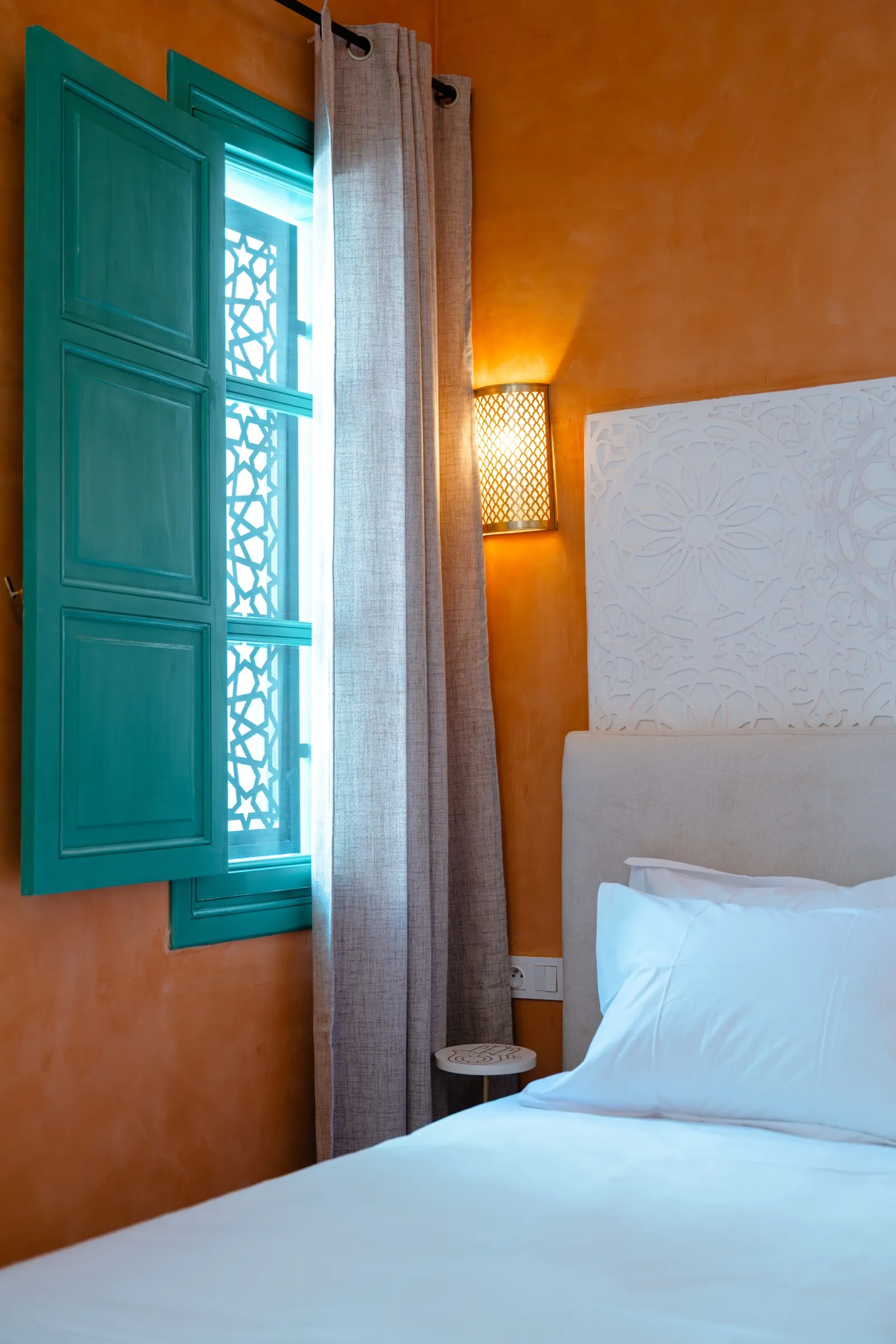 Chambre safran avec volets verts et lumière naturelle