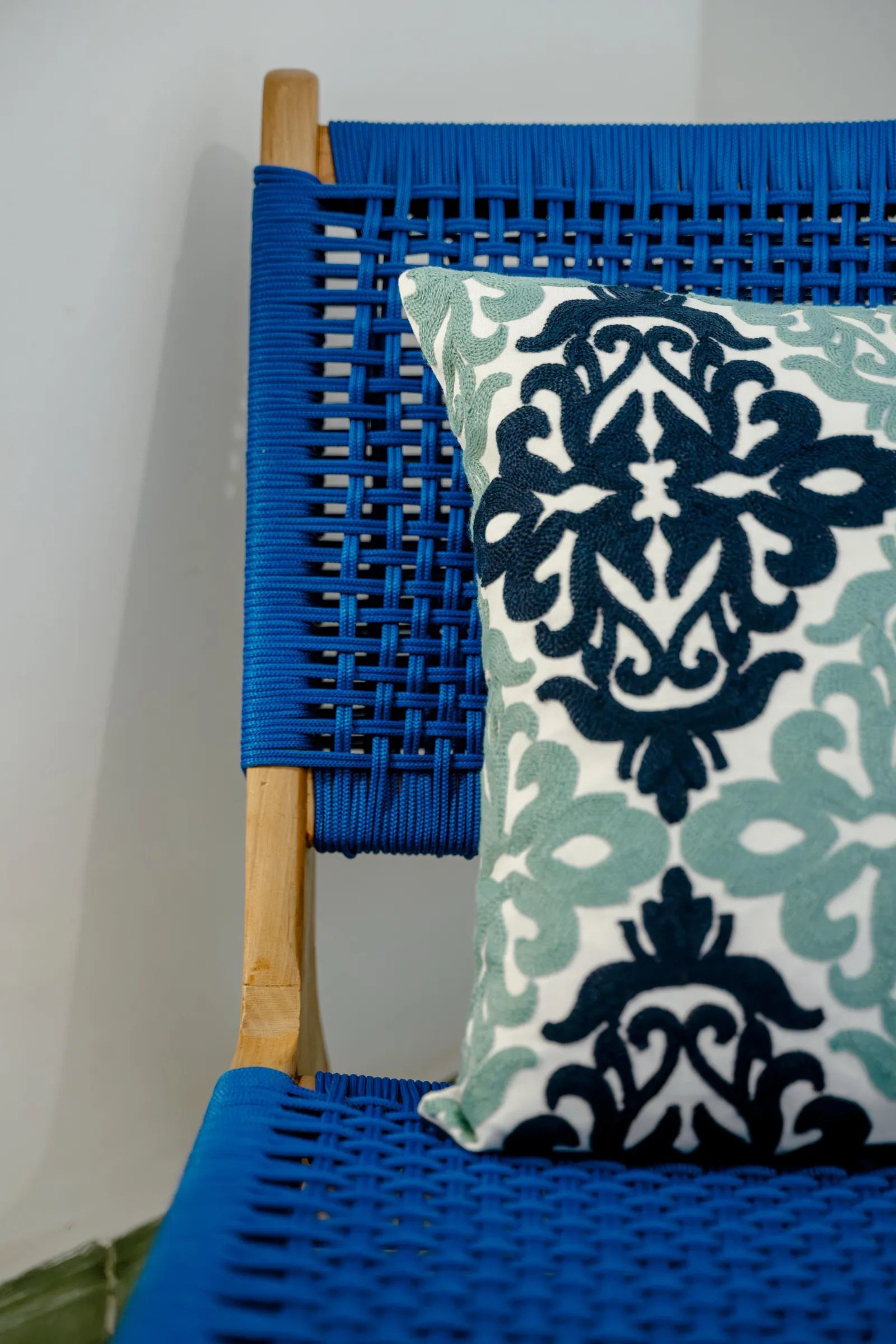 Chaise tissée bleue et coussin à motifs