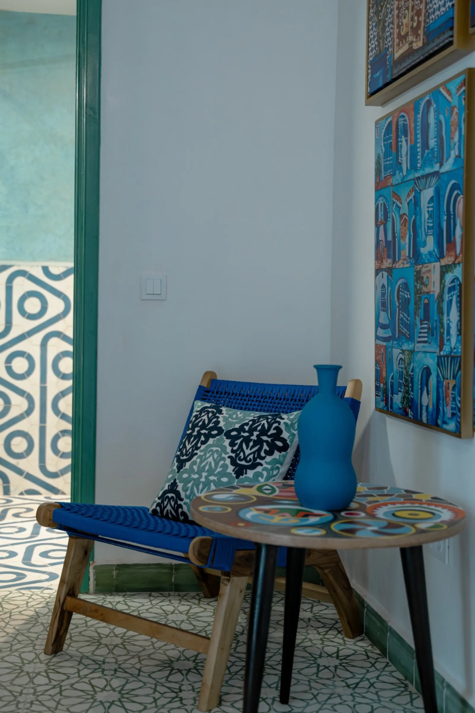 Chaise bleue et vase sur fond de tableaux marocains