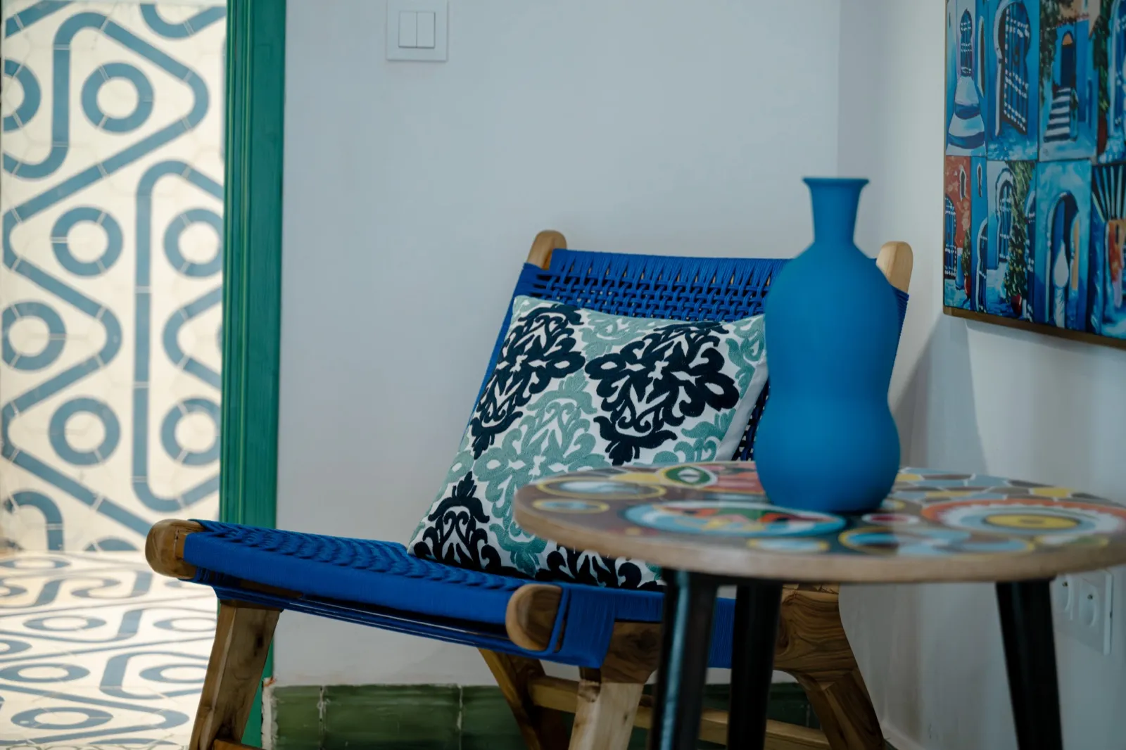 Coin lecture avec chaise bleue, vase et tableau