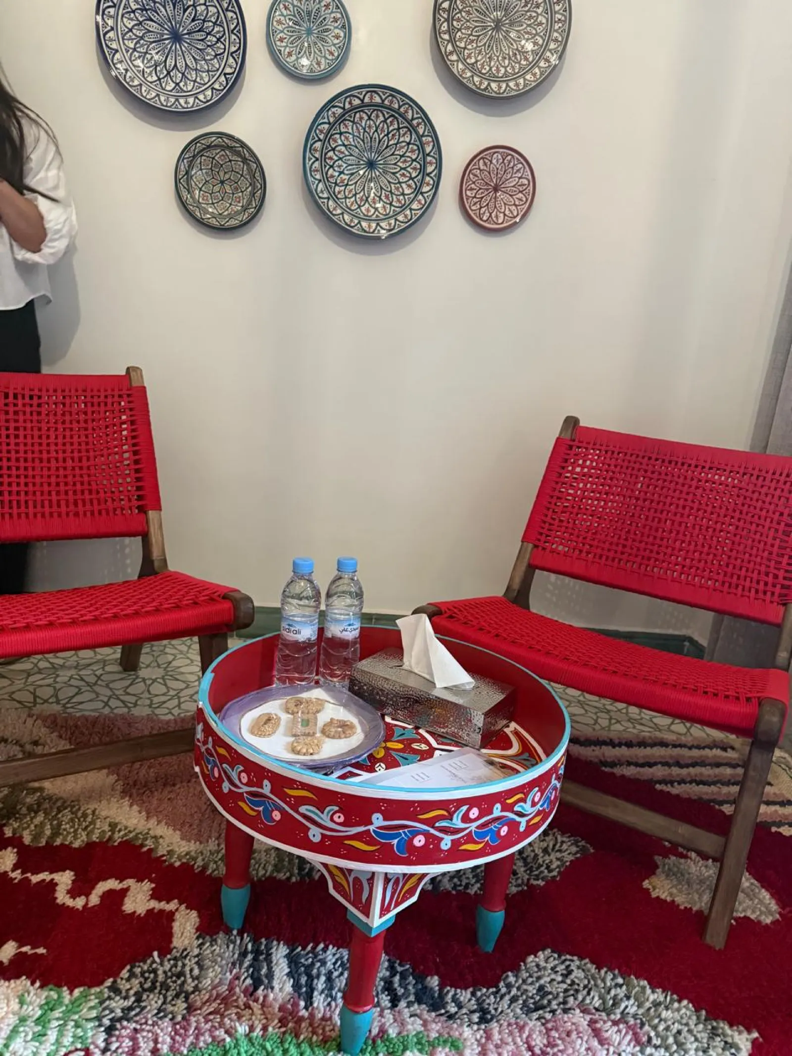 Coin accueil avec chaises rouges et table peinte