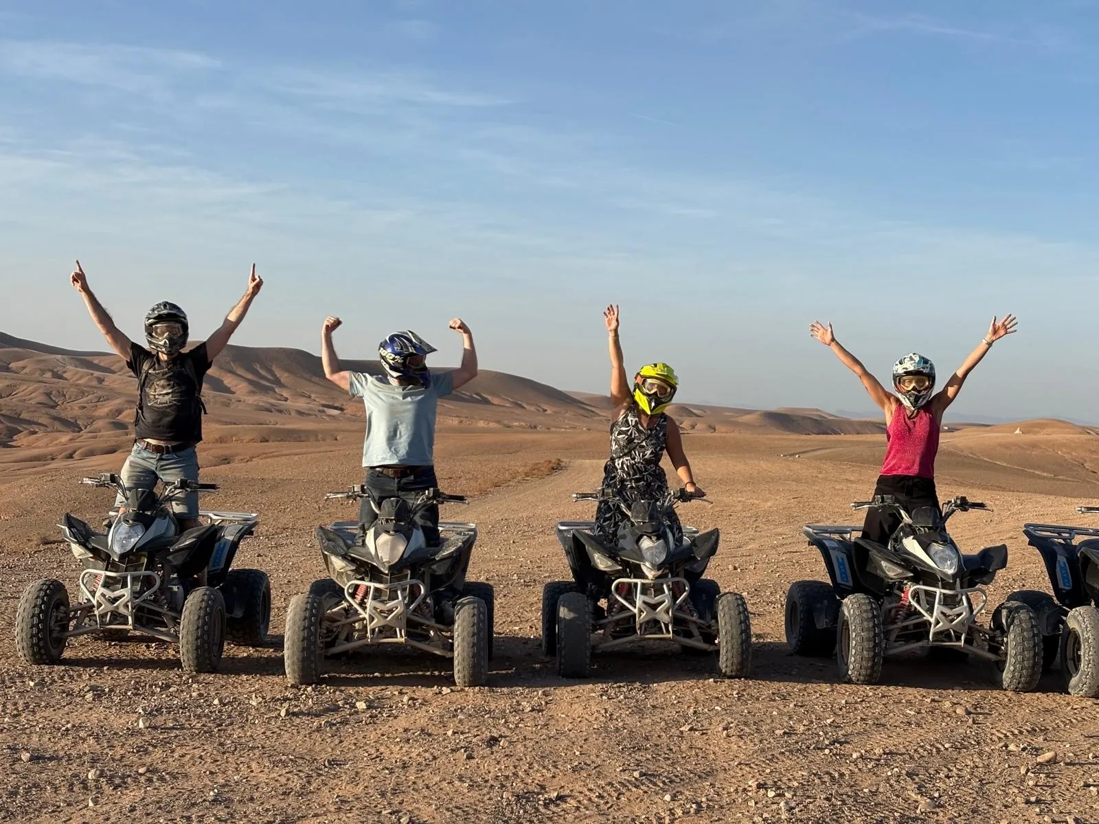 Groupe en quad bras levés dans le désert