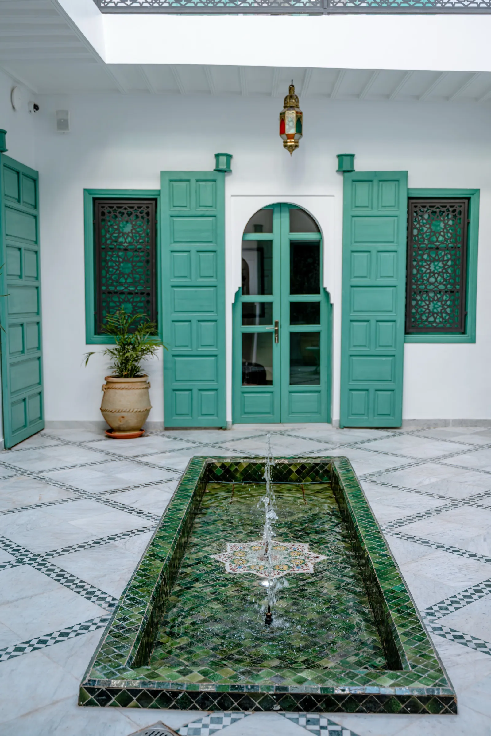 Fontaine en zellige et porte traditionnelle du patio