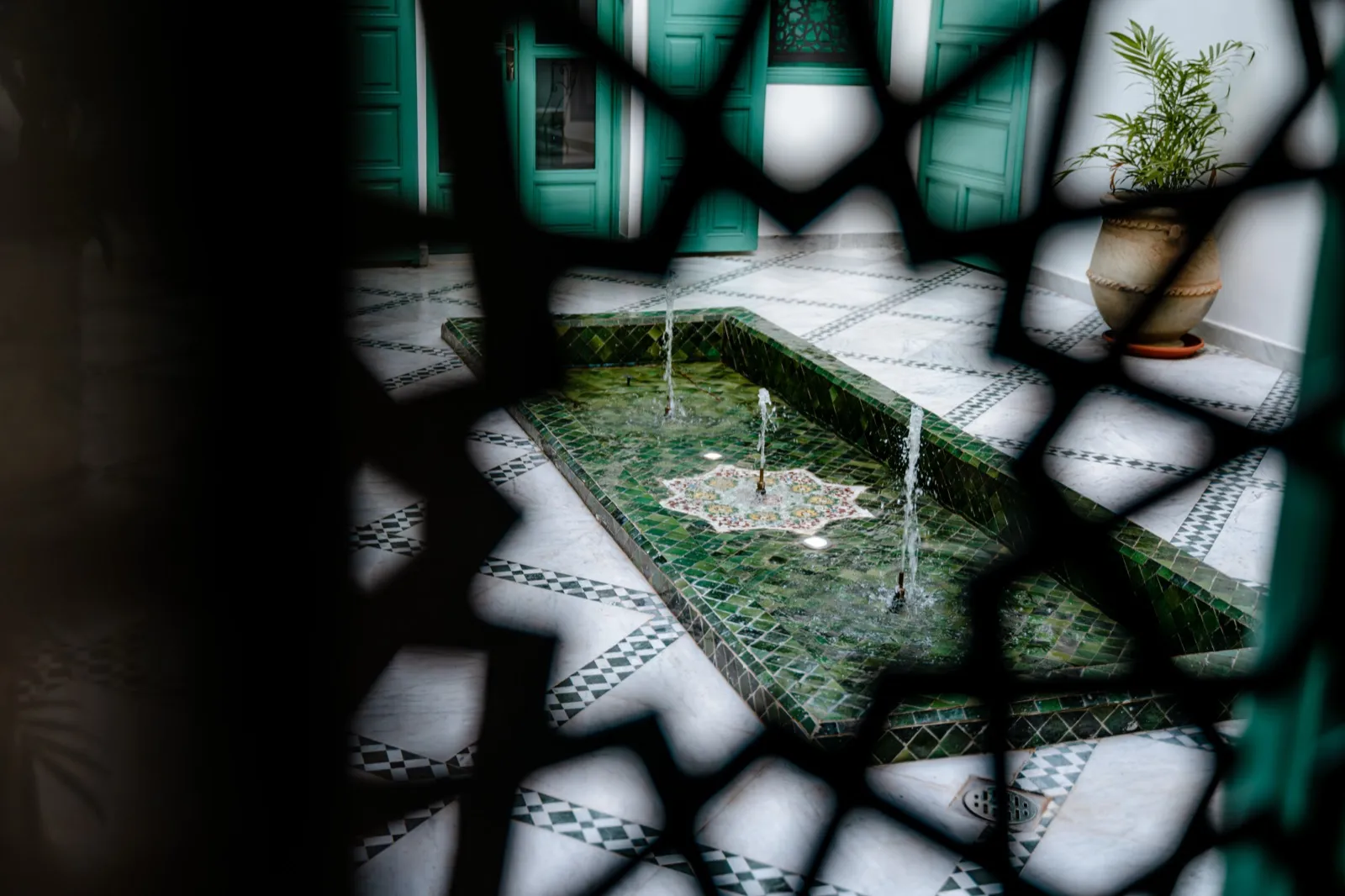 Fontaine et fer forgé vus à travers le moucharabieh
