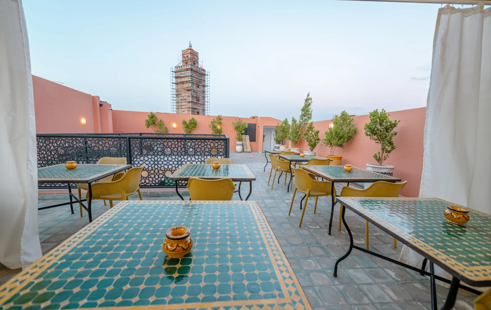 Tables en zellige sur le rooftop au crépuscule