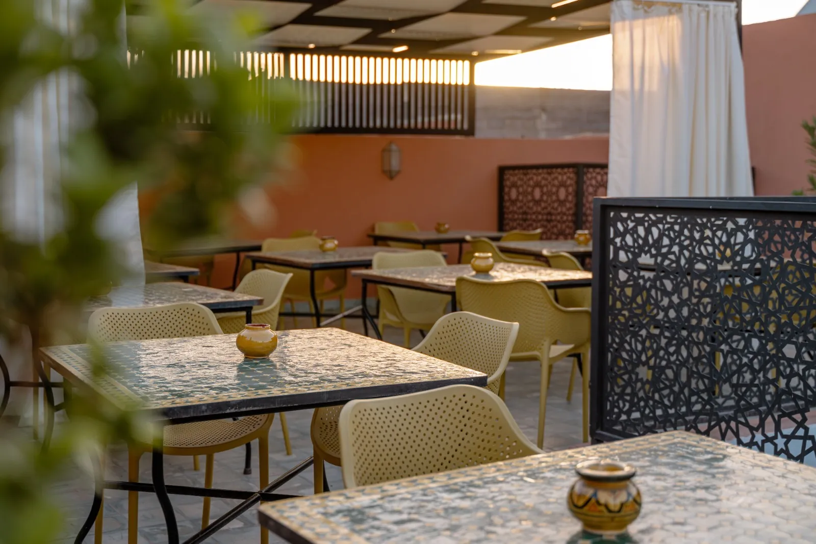 Tables dressées sur le rooftop à l'heure dorée